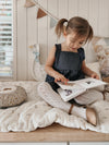 Young child wearing dark indigo organic cotton overall dress outdoors