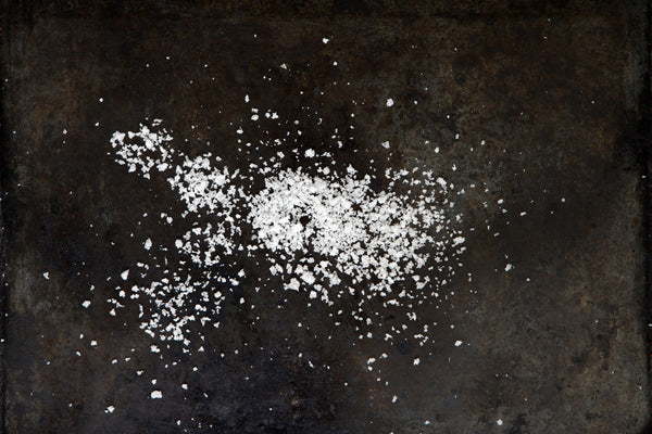 White salt crystals on a dark textured surface