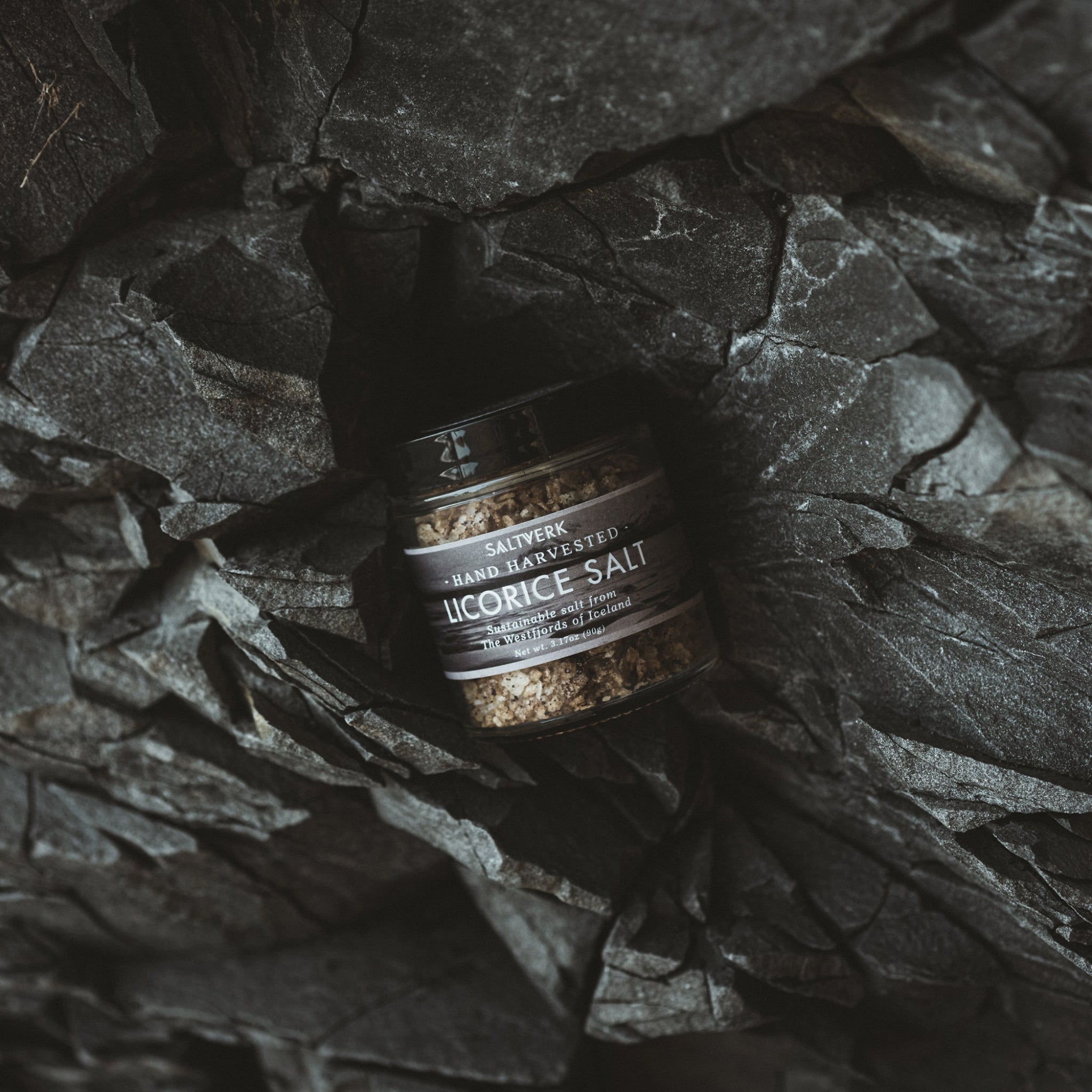 Bottle of licorice salt on a dark stone surface