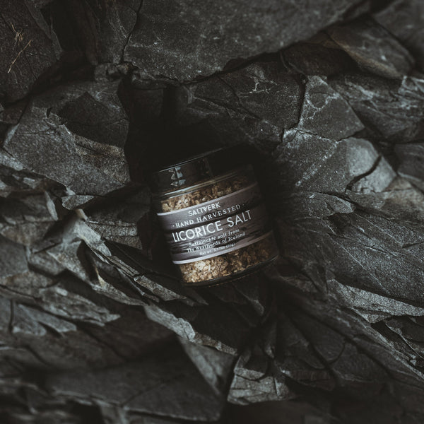 Bottle of licorice salt on a dark stone surface