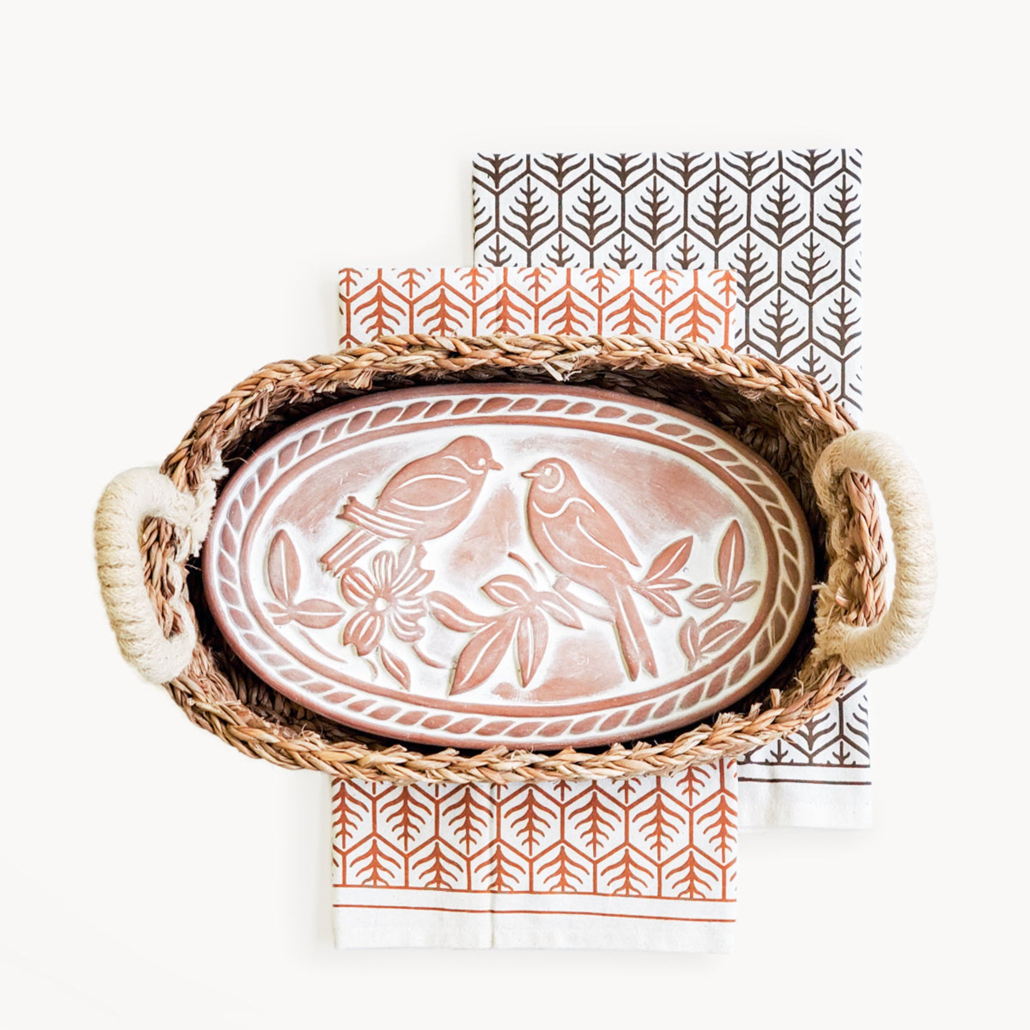 Decorative tray with bird design in a wicker basket on a white background