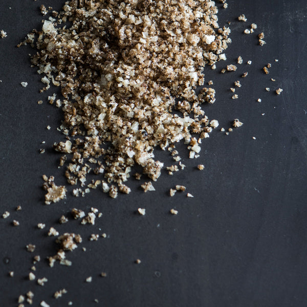 Close-up of ground spice and salt on a dark surface