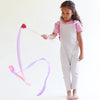 Child playing with a colorful bow and arrow toy on a white background
