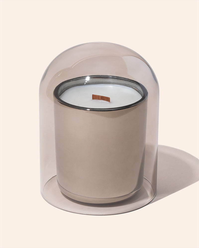 Translucent dove cloche covering a candle on display for retail or market setup