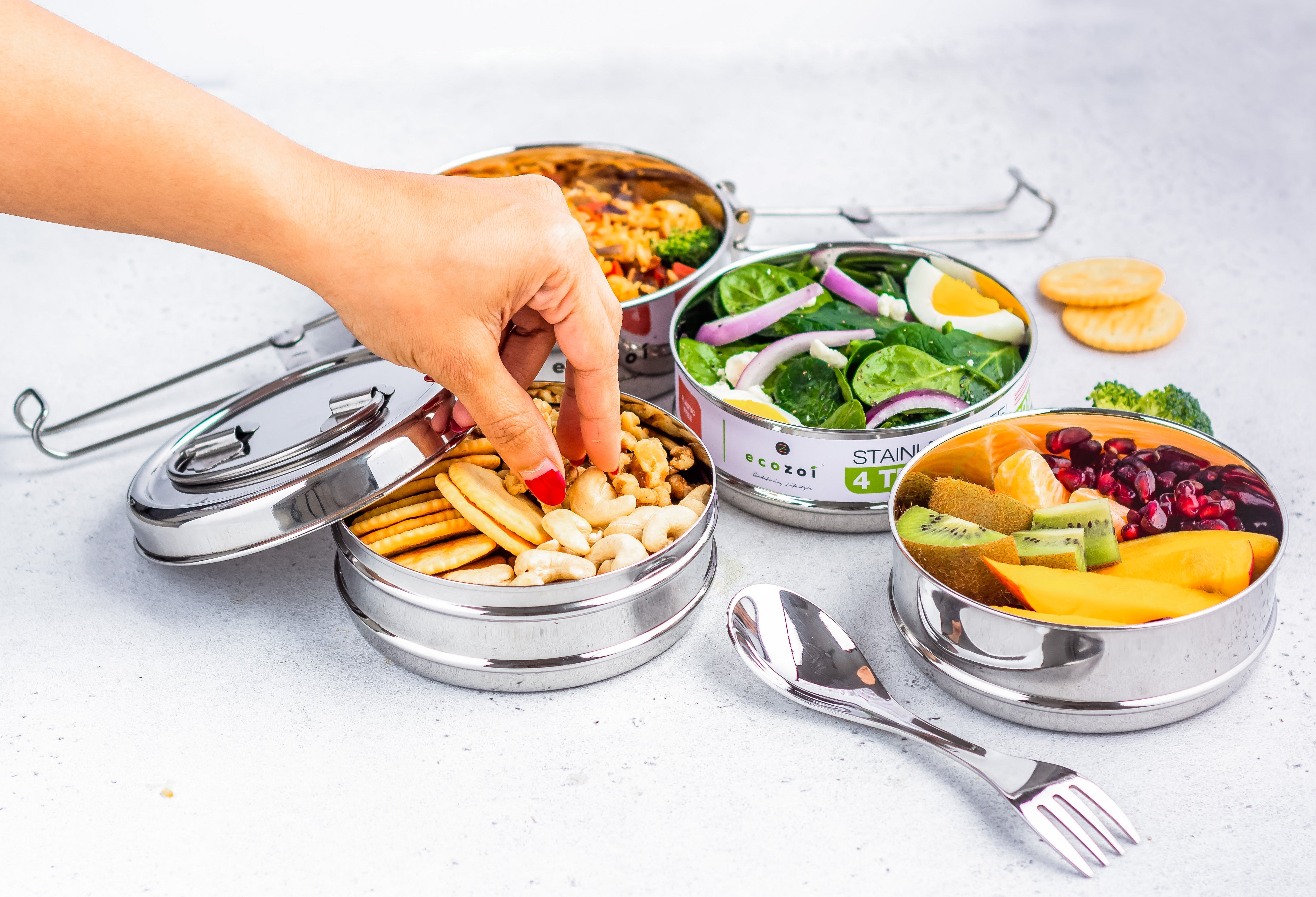 Ecozoi round bento lunch box open with stainless steel spork resting on top tier