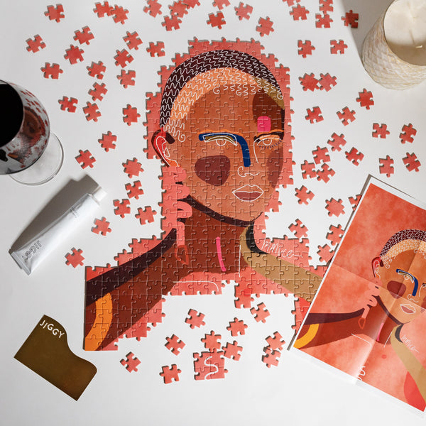 Jigsaw puzzle with a partially completed portrait of a person, surrounded by puzzle pieces and a box labeled 'JIGGY'.