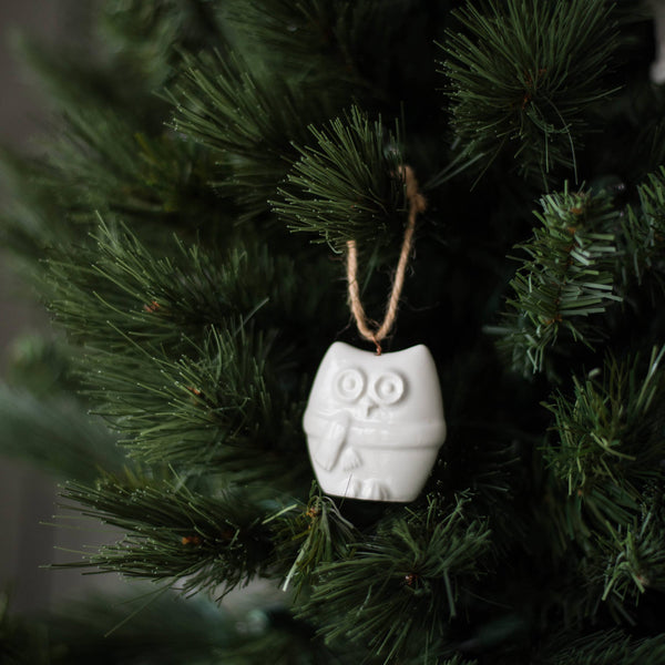 Detail of handcrafted porcelain ornament showing smooth glazed finish and rustic jute loop