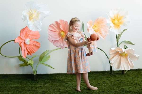 Apple Park Summer Bounty doll dress with flutter sleeves styled on a doll, displayed in a bright lifestyle setting