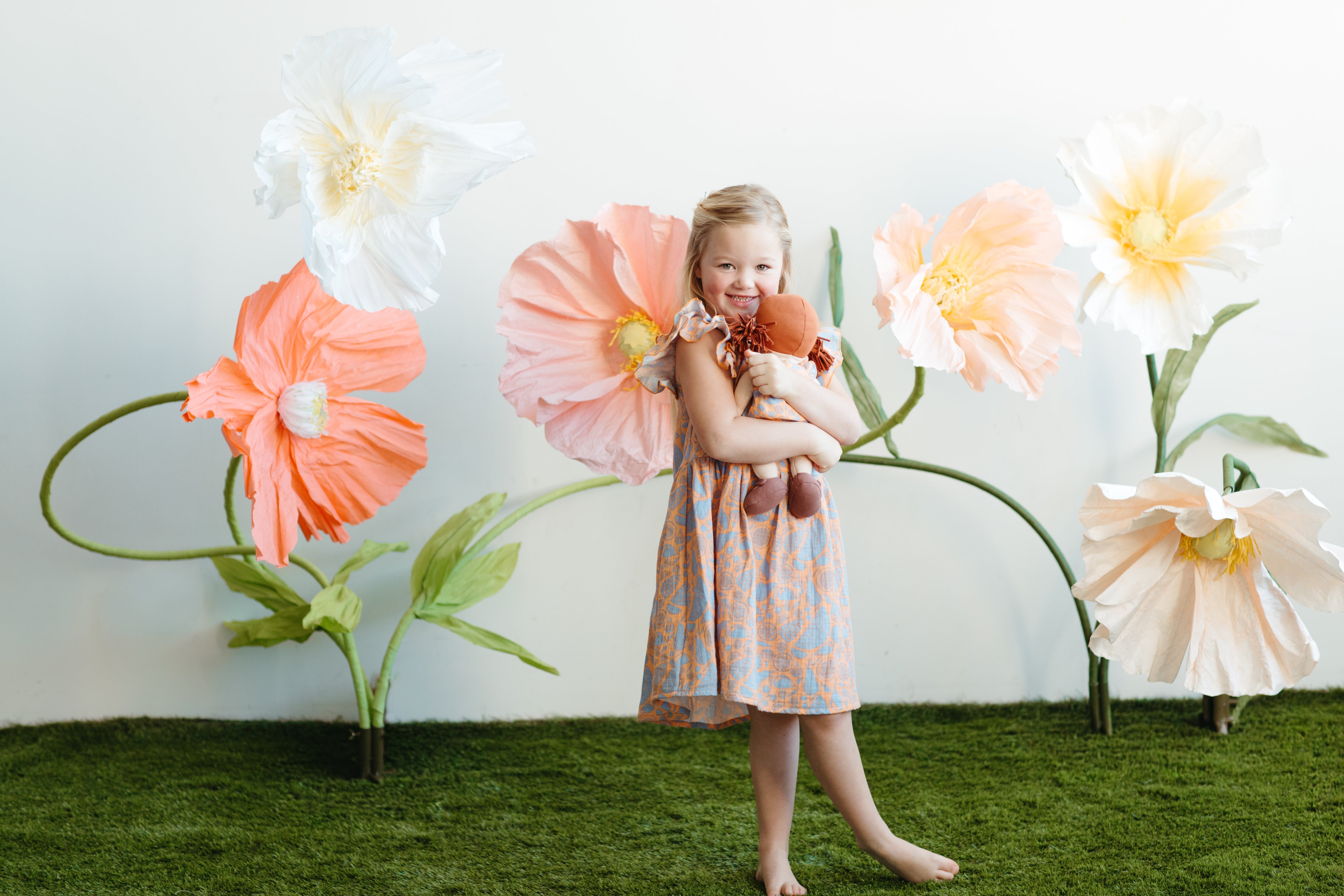 Close-up of Apple Park Summer Bounty doll dress on a doll, highlighting the flutter sleeve detail and fruit print fabric