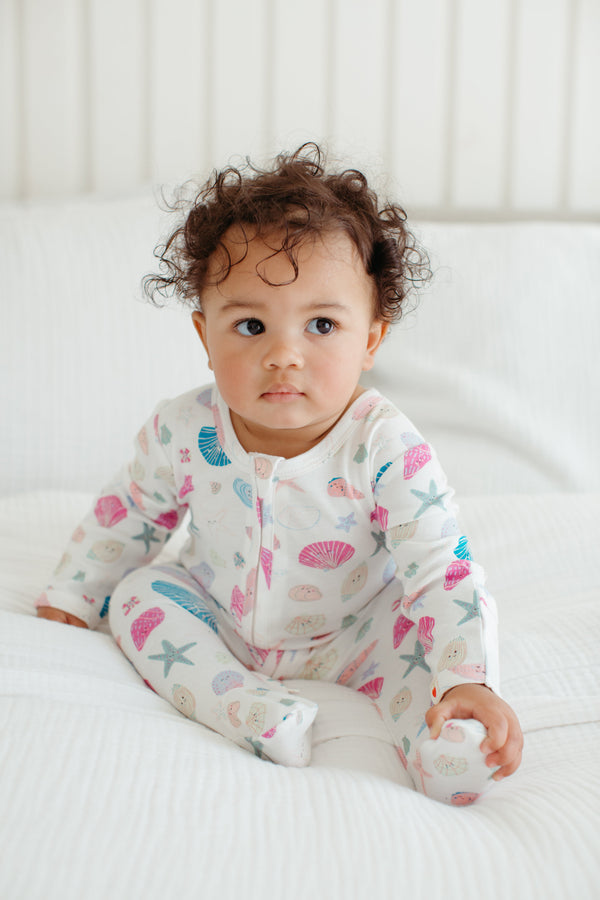 Baby wearing the Seaside Treasures bamboo zip footie romper with ocean-themed print