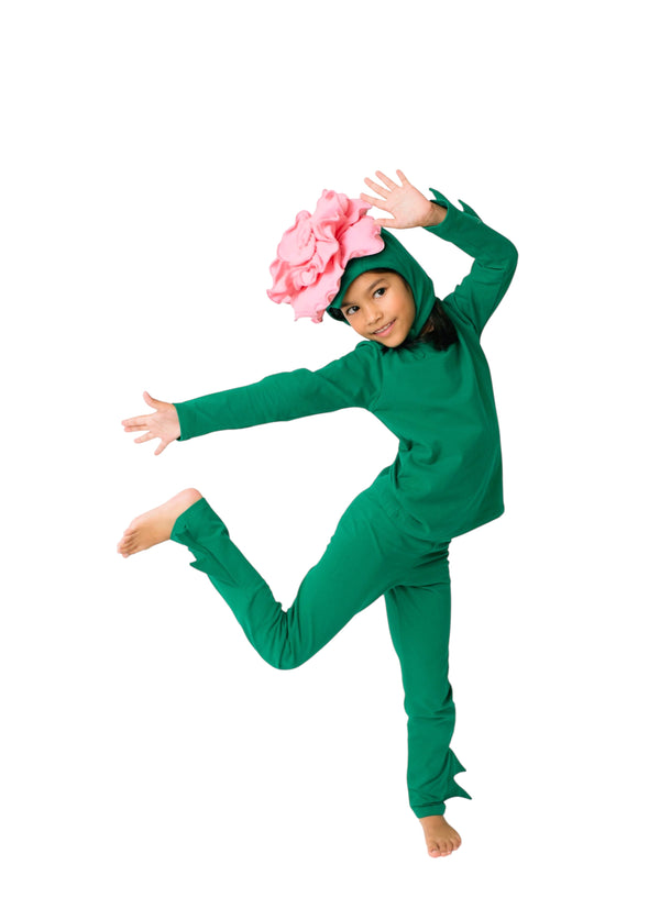 Child in a green costume with a pink flower on a white background