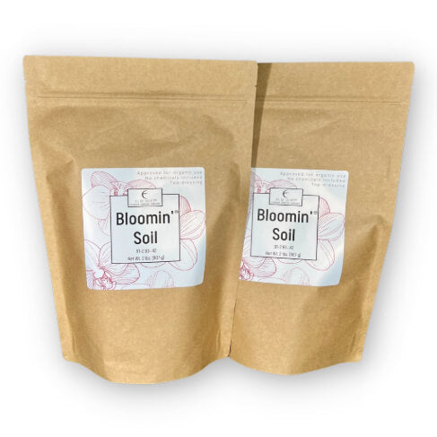Two brown paper bags with 'Bloomin' Soil' labels on a white background
