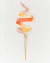 Colorful cotton candy on a stick against a white background