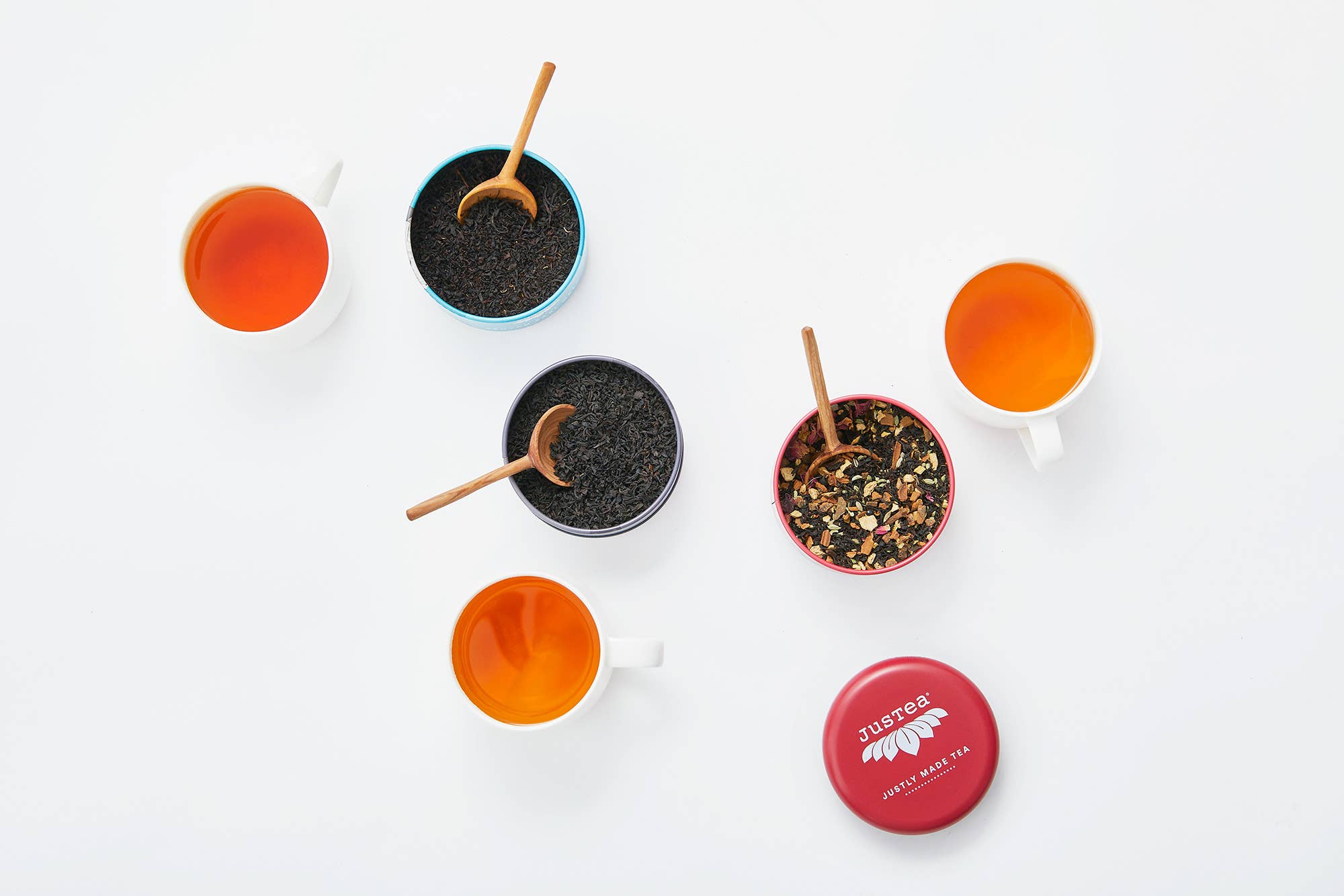 JusTea organic fair-trade whole leaf black tea trio arranged as a gift set with tins stacked neatly