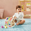 Baby playing with a colorful wooden toy on a blue rug.