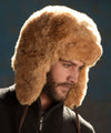 Man wearing a brown fur hat against a dark background