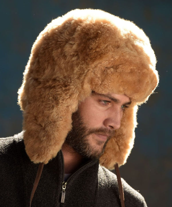 Man wearing a brown fur hat against a dark background