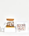 Jar of assorted candies with a box of candy pieces on a white background