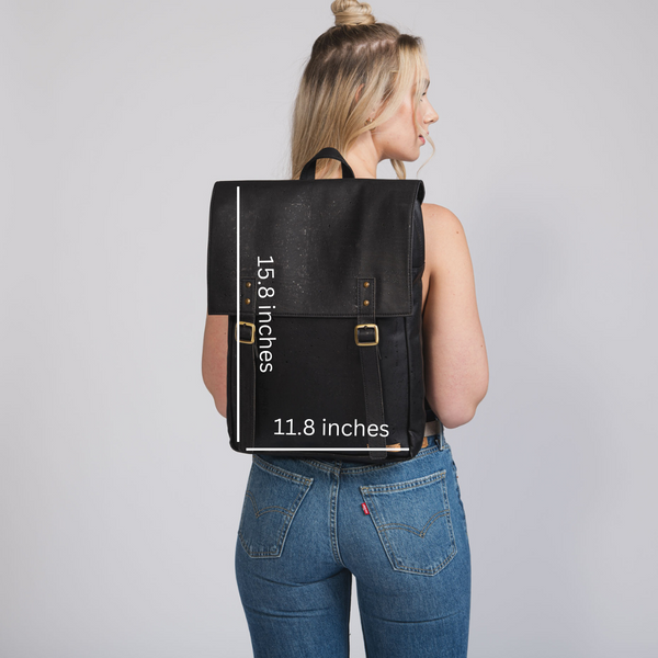 Person wearing a black backpack with dimensions printed on it against a gray background