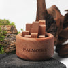 Wooden puzzle with blocks in a wooden bowl labeled 'Palmoire' against a natural background.