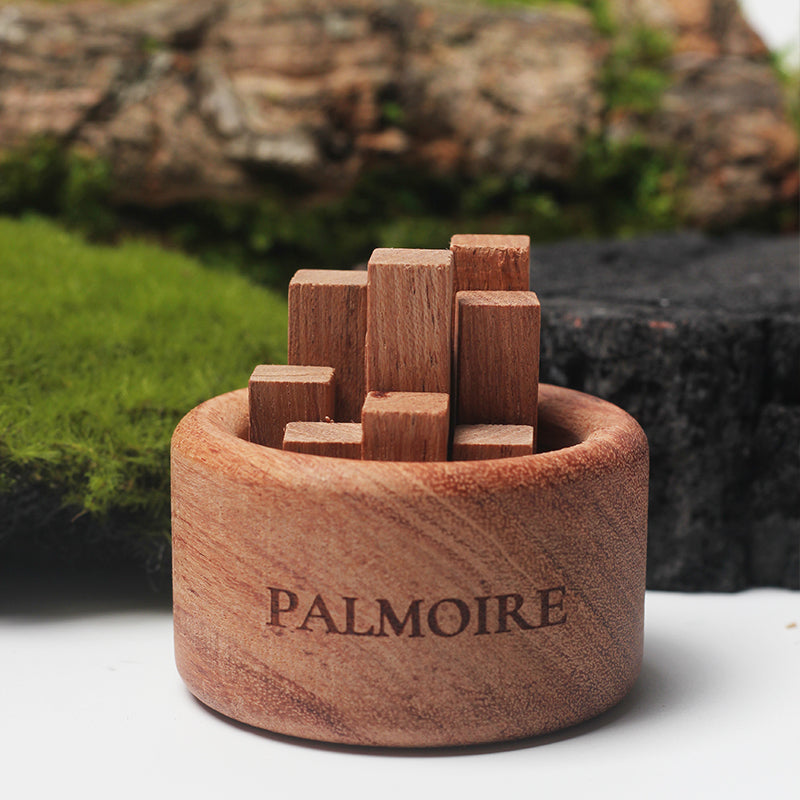 Wooden puzzle with pieces inside a wooden base, branded 'Palmoire', against a natural background.