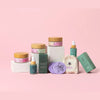 Collection of skincare products on a pink background