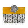 Yellow clutch with black and white patterned flap and flower accessory on a white background