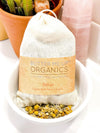 Close-up of loose organic herbal bath tea ingredients including lavender, neem, oatstraw, and pink rose petals for a calming bath soak