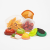 Set of toy fruits and vegetables with transparent containers holding oranges and strawberries on a white background.