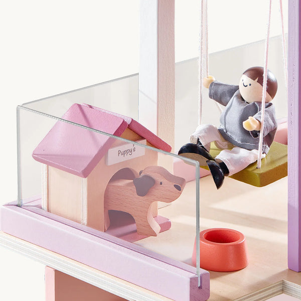 Children's playset with a doghouse, dog, and child on a swing.