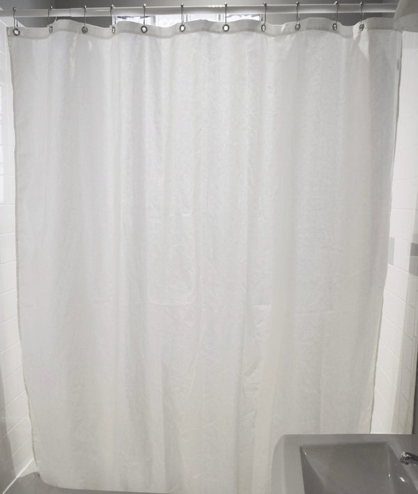 White shower curtain hanging in a bathroom with a sink visible.