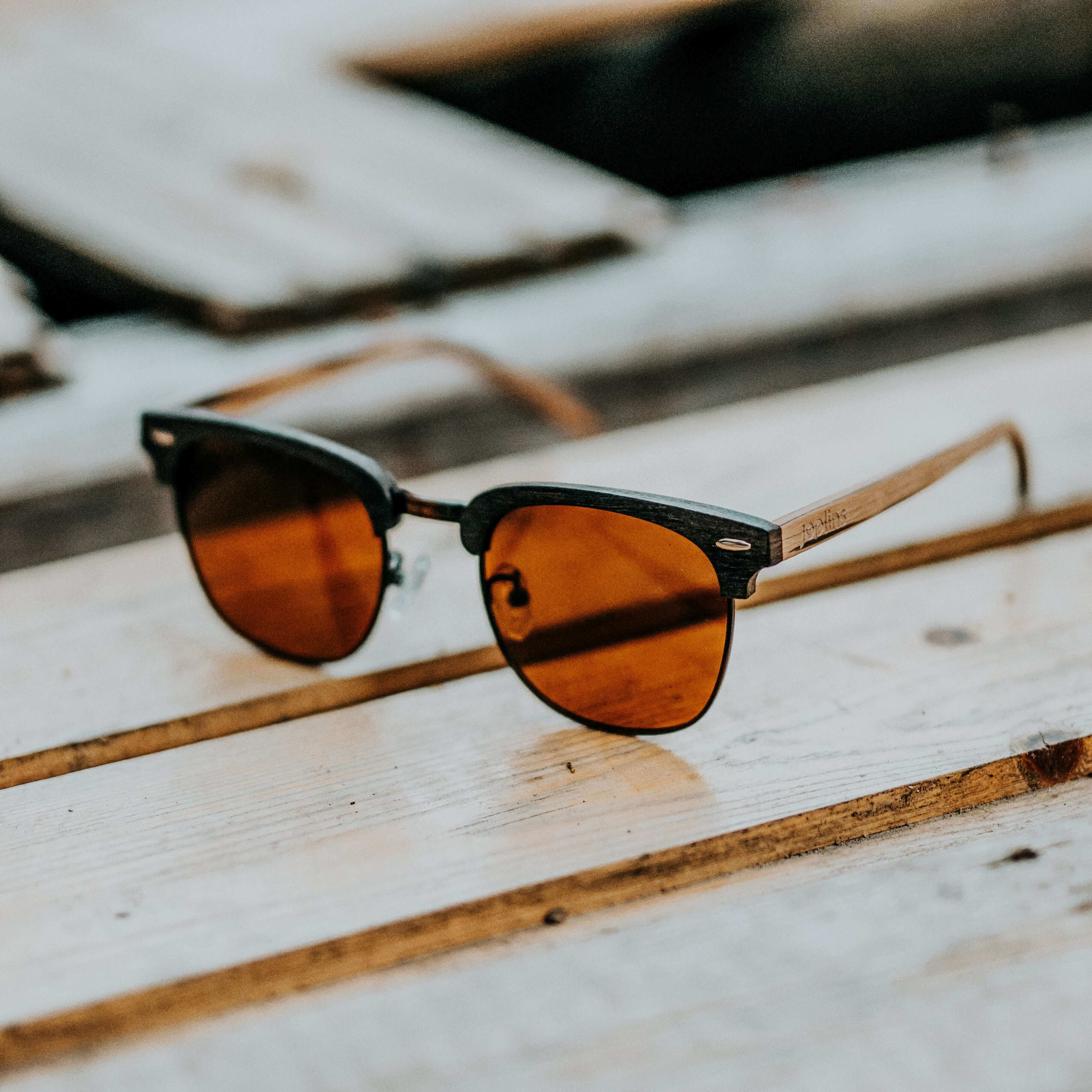 Sunglasses with brown lenses on a wooden surface