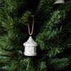 White ceramic lantern ornament on a green Christmas tree