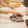Plum+Sparrow Thistle knitted blanket draped in a nursery setting, showing muted purple-grey tone