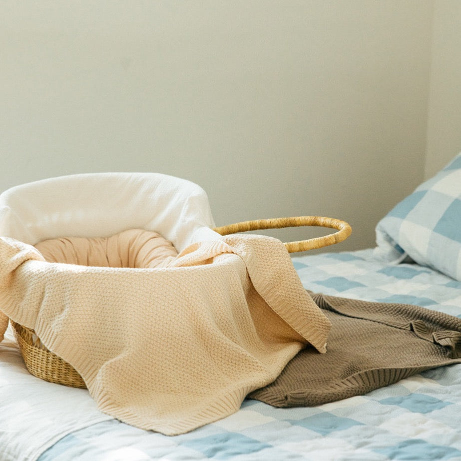 Plum+Sparrow pewter cotton knitted baby blanket styled in a nursery setting as a swaddle or cot layer