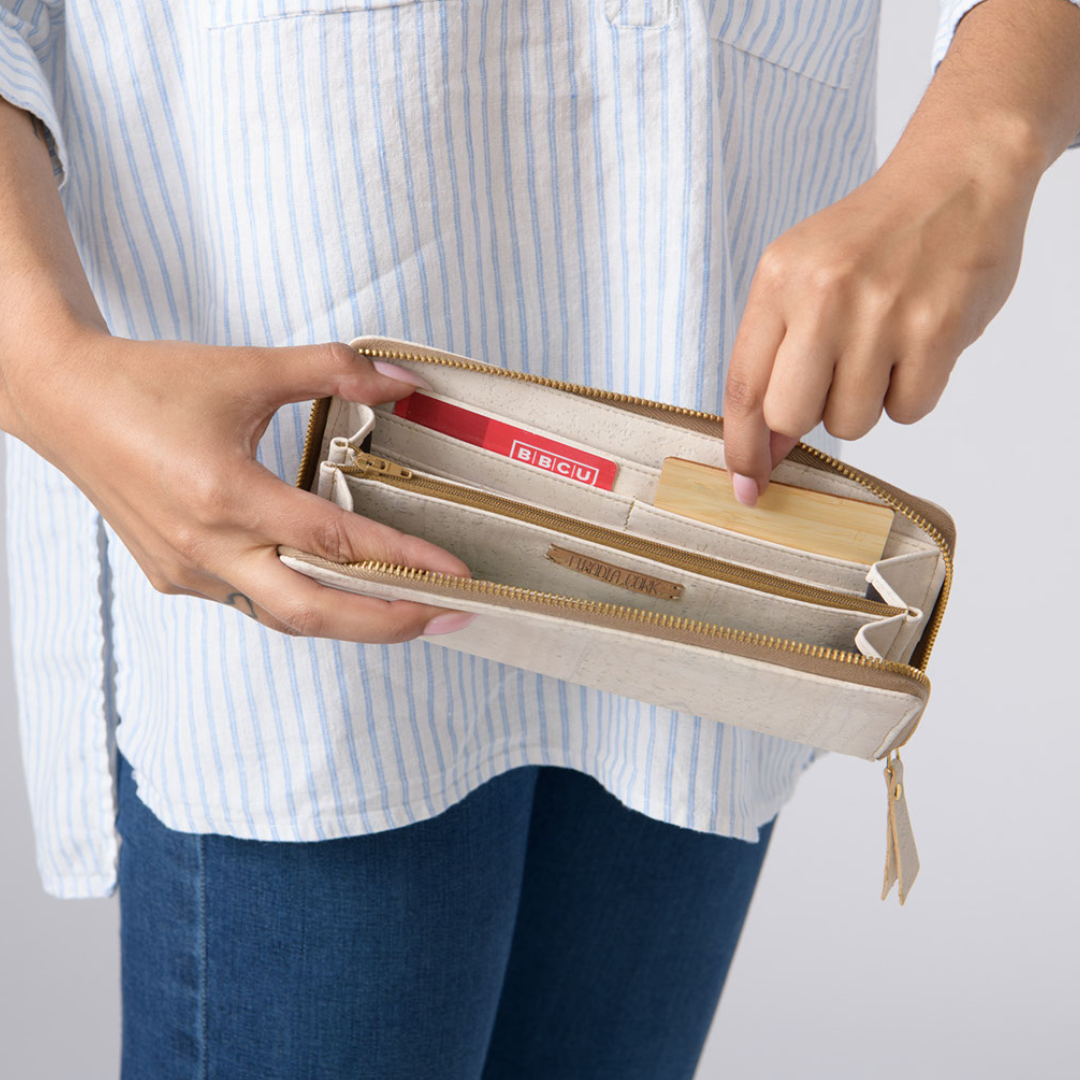 Person holding a beige wallet with a white background