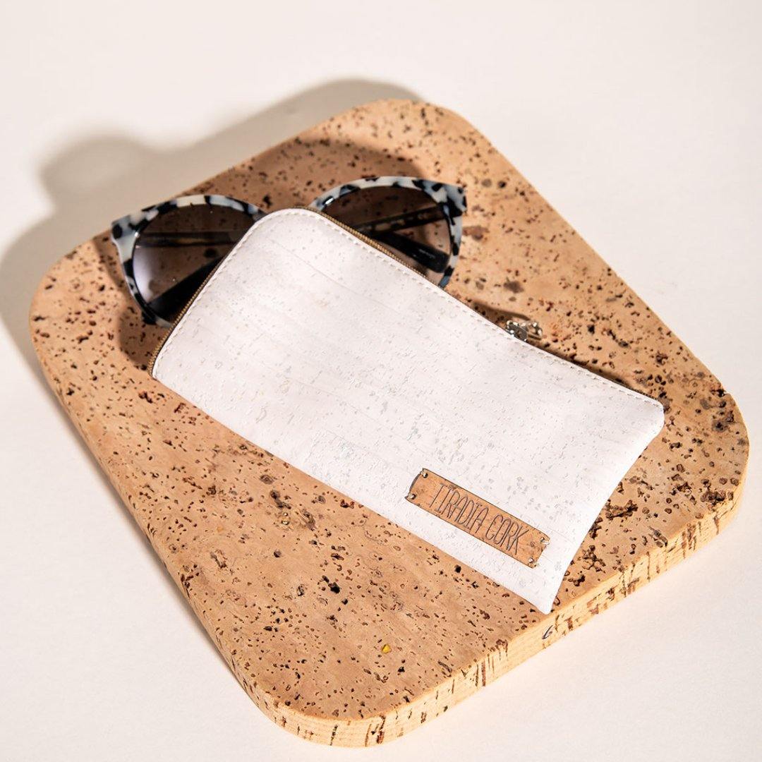 Cork coaster with sunglasses and phone on a light background