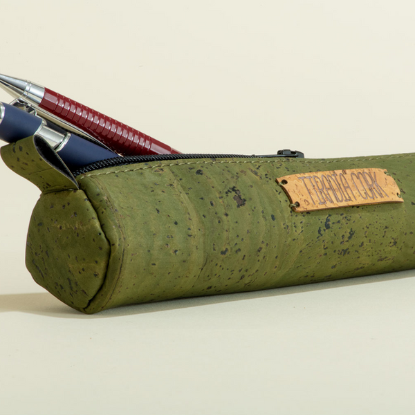 Green cork pencil case with pens on a beige background