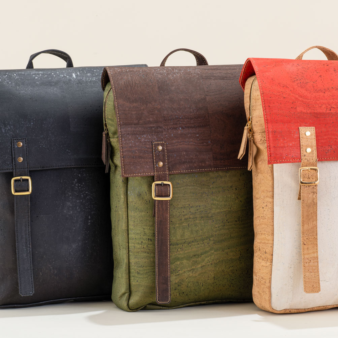 Three backpacks in black, green, and multicolor on a light background