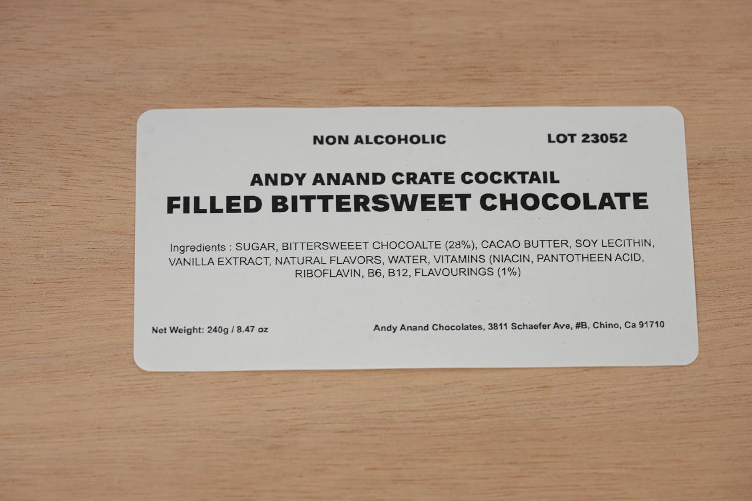 Label for Andy Anand Crate Cocktail Filled Bittersweet Chocolate on a wooden surface