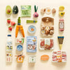 Tiny Land Organic Wooden Play Food Collection spread out on a surface showing meats, vegetables and dairy pieces