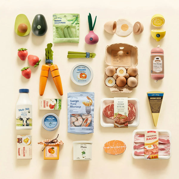 Tiny Land Organic Wooden Play Food Collection spread out on a surface showing meats, vegetables and dairy pieces