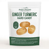 Individually wrapped Andy Anand ginger turmeric hard candies displayed on a surface