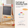 Wooden drawing easel with chalkboard surface, paint cups, and paper rolls in a home setting.