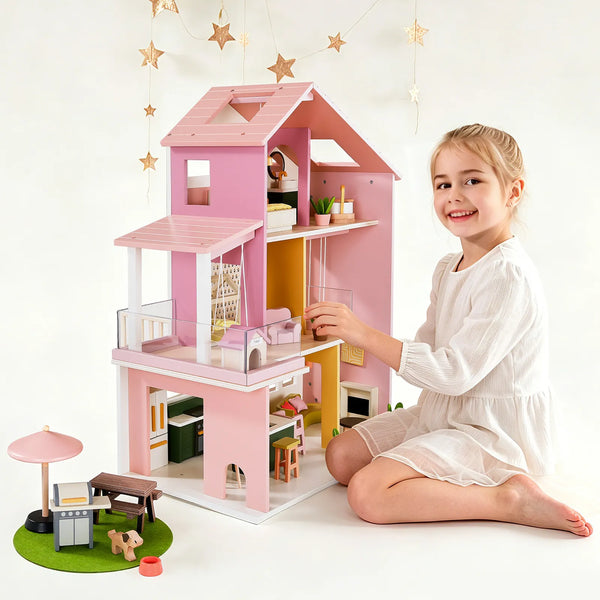 Young girl playing with a pink dollhouse on a white background