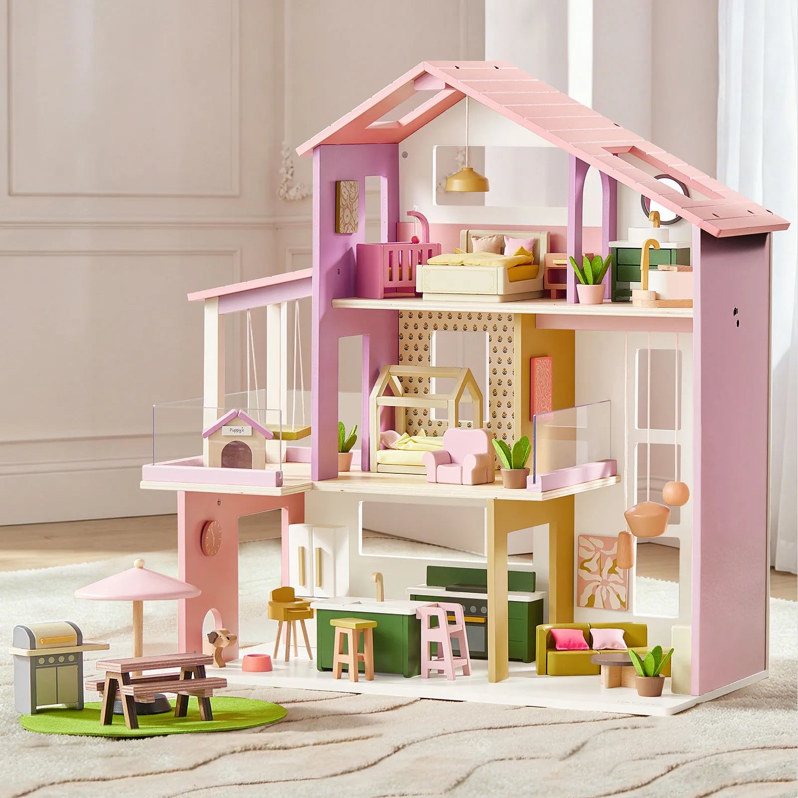 Pink and white dollhouse with detailed furniture and decor on a neutral background