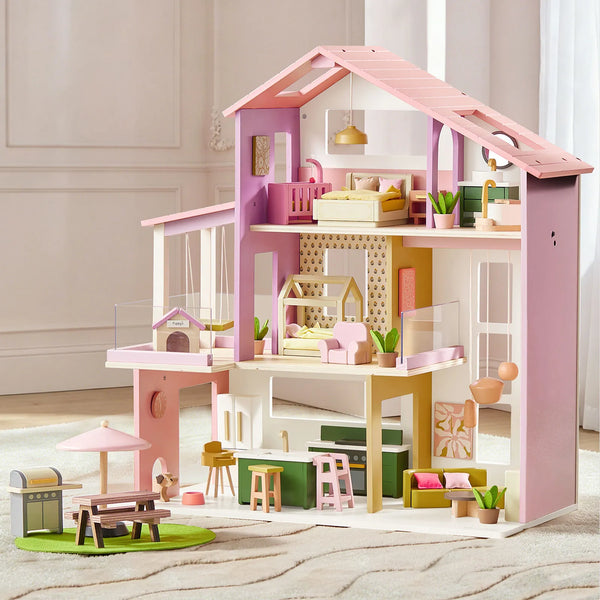 Pink and white dollhouse with detailed furniture and decor on a neutral background