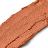 Close-up of a swatch of brown makeup cream on a white background