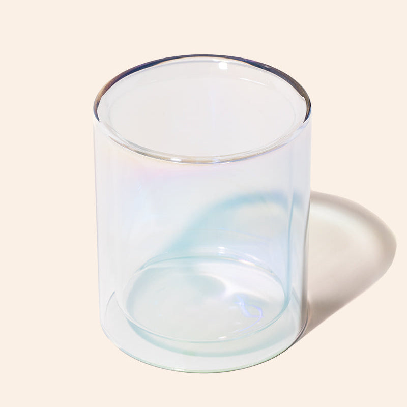 Clear glass candle holder on a beige background