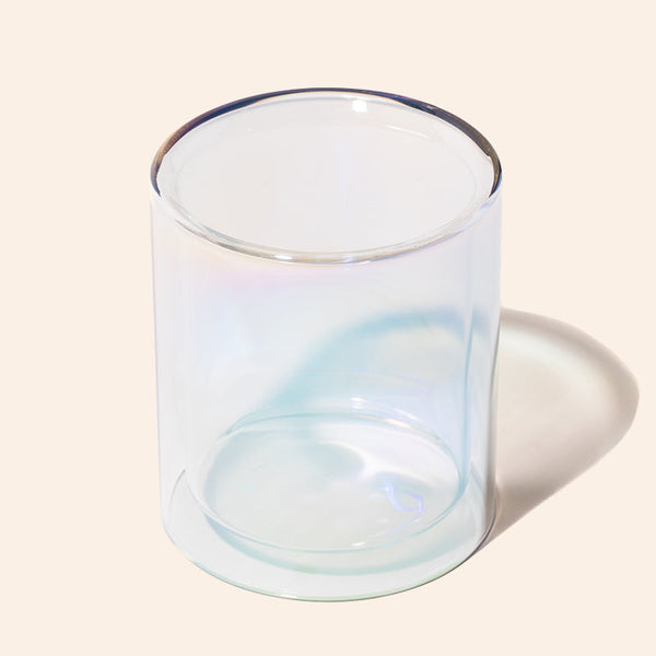 Clear glass candle holder on a beige background